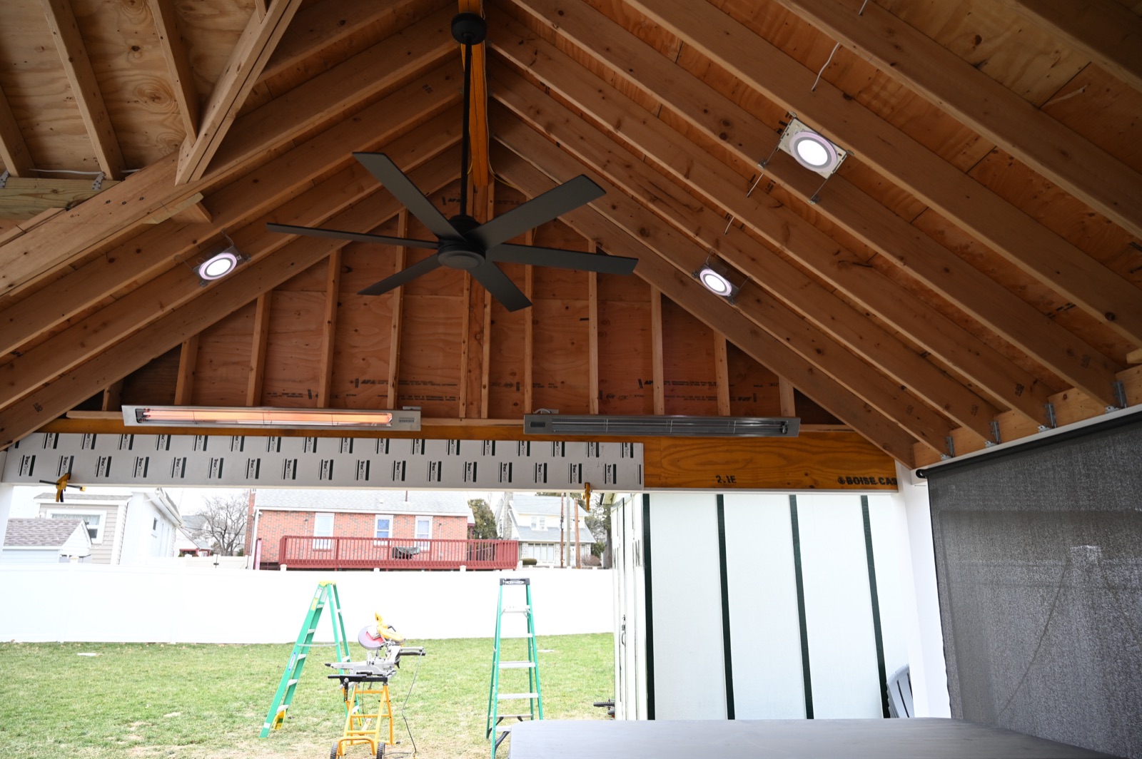 Covered patio addition with vaulted wood ceiling, ceiling fan, and recessed lighting
